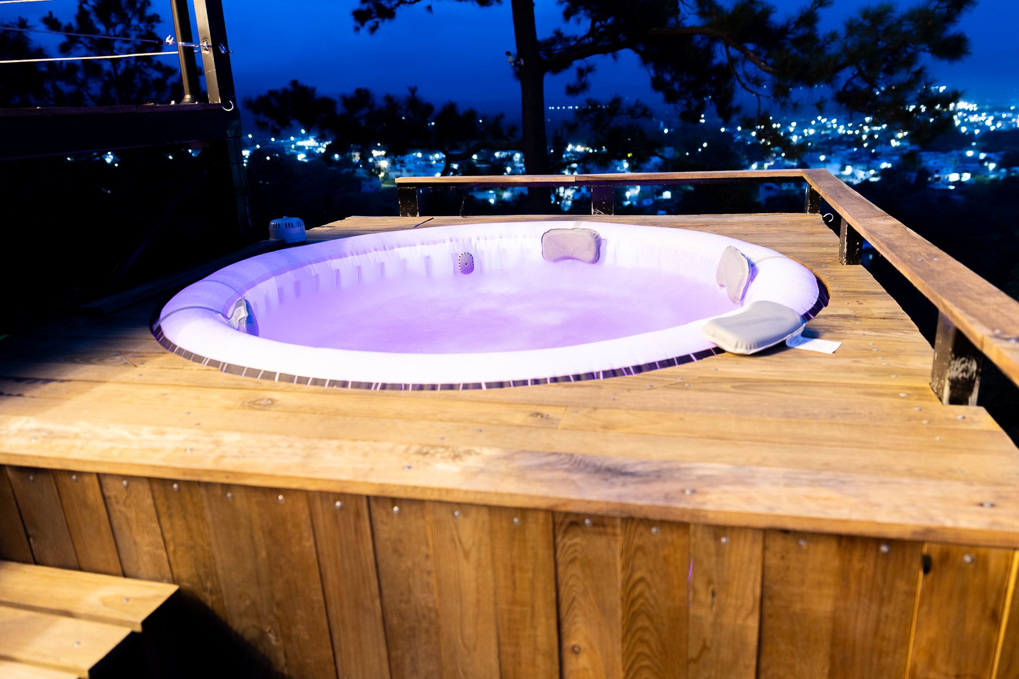 Jacuzzi iluminado en el deck con la ciudad de Esquipulas de noche