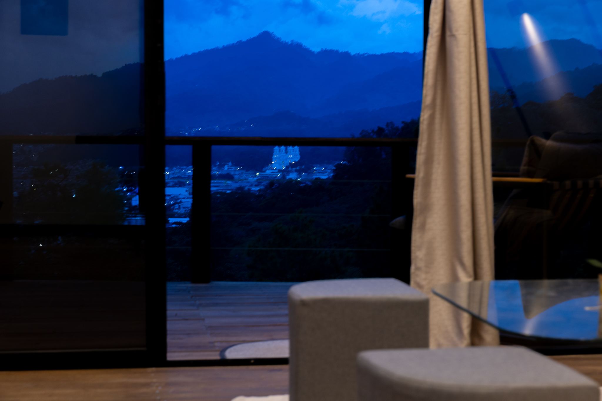 Vista a las montañas y la ciudad desde la sala, al anochecer